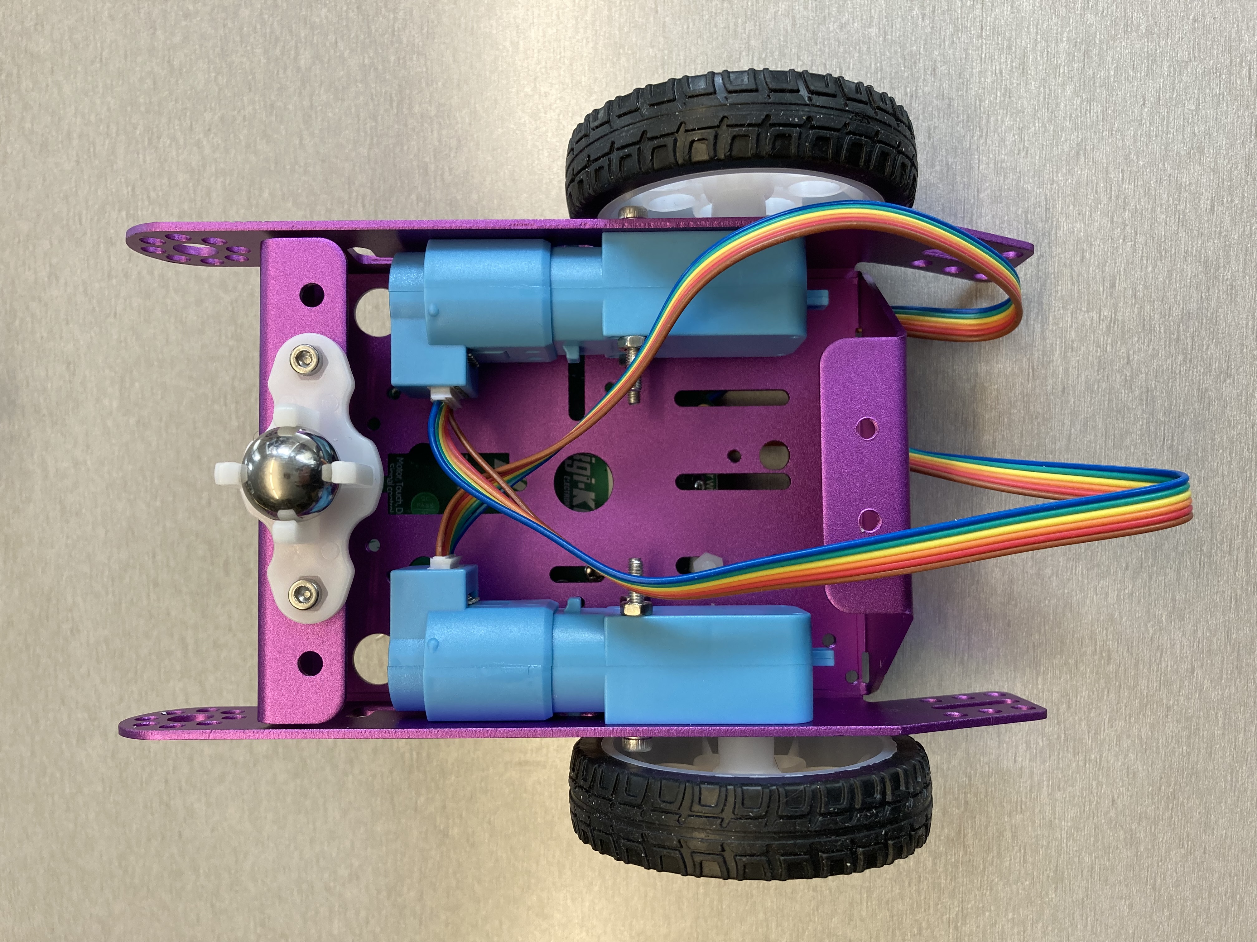 A prototype of an open robot with a purple chassis and two blue motors.