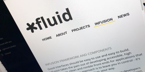 A photograph of a monitor showing the Fluid Project website